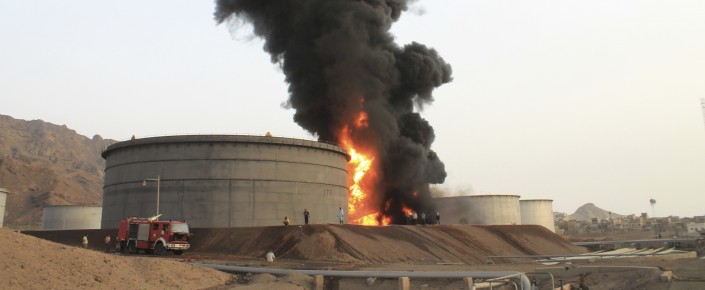 Firefighters work to extinguish a fire following rocket attacks by Houthi fighters at storage tanks of an oil refinery in Aden, Yemen, July 14, 2015. (AP Photo/Abo Muhammed)